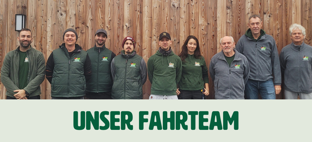 KI generiert: Das Bild zeigt eine Gruppe lächelnder Personen, die vor einer Holzwand stehen und Teamkleidung tragen. Darunter steht der Text "Unser Fahrteam".